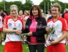 Antrim Camogie Vice Chairman presenting Senior Feis Camogie Final Captain Charlene Campbell with the Senior Feis Camogie Trophy and Emma McMullan with player of the match