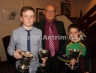 Former North Antrim Treasurer Harry Connolly presents the Under 12 Championship cup to Oisins captain Shea McDonnell and the Under 10 Championship Cup to Patrick McIlwaine