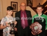 Former North Antrim Treasurer Harry Connolly presents the Feile B Cup to Higgins (left) and the Under 12 B Shield to Thomas O'Kane of Con Magees Glenravel